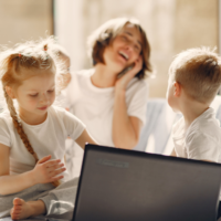 famiglia madre e tre figli davanti al pc felici per il welfare